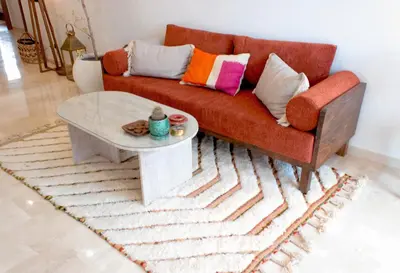a living room with a red couch and a table at Appartement Haut Standing 2 Chambres avec 2 Terrasses au Centre Gueliz Marrakech in Marrakech