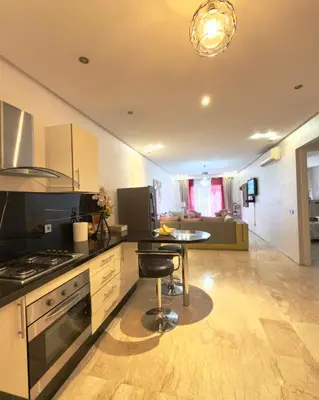 a kitchen with a stove and a table in it at Apartment gueliz in Marrakech