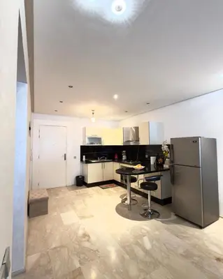 a kitchen with a table and a refrigerator at Apartment gueliz in Marrakech