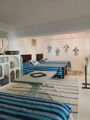 a room with two beds and a table in it at Loft Harmonia in Marrakech