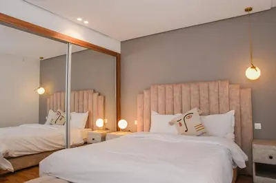 a bedroom with two beds and a large mirror at Éminence Living in Marrakech