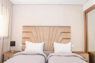 a bedroom with two beds and a headboard at Éminence Living in Marrakech