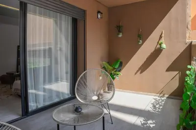 a patio with a rattan chair and a table at Éminence Living in Marrakech