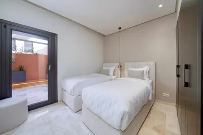 two beds in a room with a window at Plaza Marrakech Comfort Stay in Marrakech
