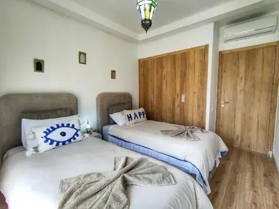two beds sitting next to each other in a room at Charming two-bedroom with terrace in Marrakesh in Marrakech