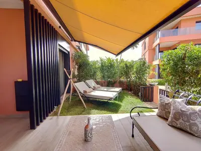 an outdoor patio with a couch and a chair at Charming two-bedroom with terrace in Marrakesh in Marrakech