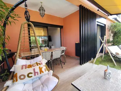 a room with a swing with pillows and a table at Charming two-bedroom with terrace in Marrakesh in Marrakech