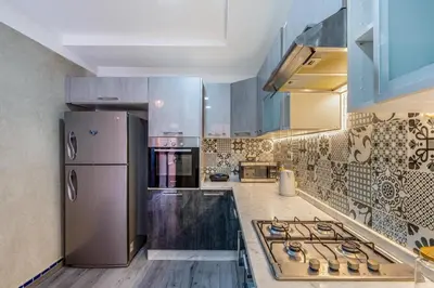 a kitchen with a stove and a refrigerator at Elegant 3-Bedroom Duplex with Pool in Marrakech
