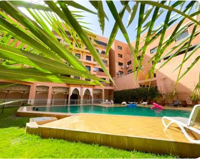 a hotel with a swimming pool in front of a building at Marrakech Guéliz Piscine & Terrasses Ensoleillées in Marrakech