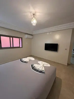 a living room with two tables and a tv at Suite Amethyste - Majorelle in Marrakech