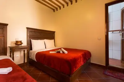 a bedroom with a bed with a stuffed animal on it at Hotel Atlas in Marrakech