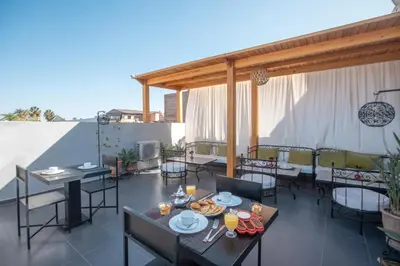 a patio with tables and chairs on a roof at Ryad Marrakech in Marrakech