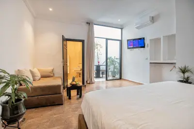 a bedroom with a bed and a couch and a tv at Ryad Marrakech in Marrakech