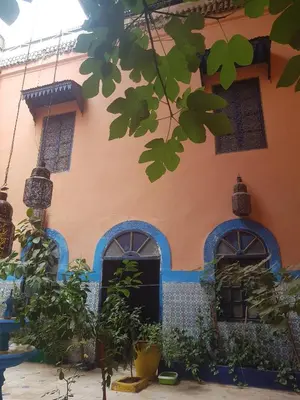 a house with blue and orange walls and windows at Riad Dar Kader chambre bleue in Marrakech