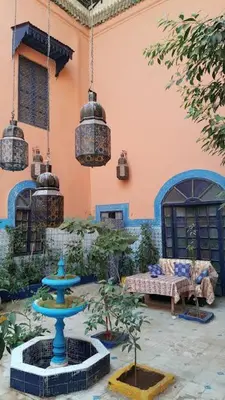 a courtyard with a blue fountain in front of a building at Riad Dar Kader chambre bleue in Marrakech