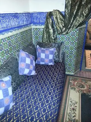 a couch with pillows on it in a room at Riad Dar Kader chambre bleue in Marrakech