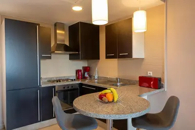 a kitchen with a table with a bowl of fruit on it at Oliva Hotel Condominium Marrakech in Marrakech