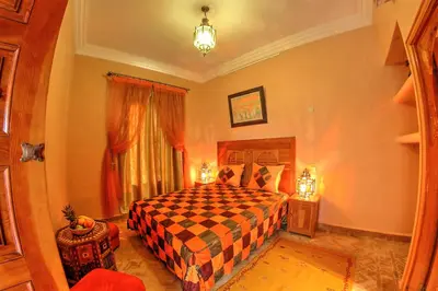 a bedroom with a bed with a checkered bedspread at Dar Tasnime in Marrakech