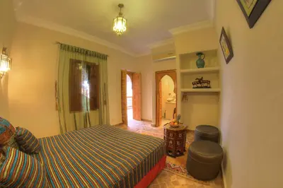 a bedroom with a bed and a couch in it at Dar Tasnime in Marrakech