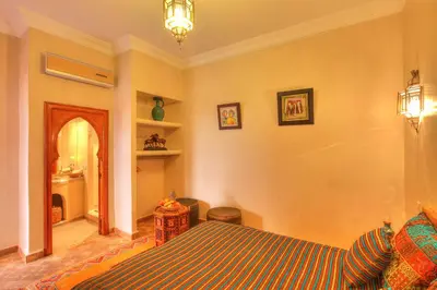 a bedroom with a bed and a living room at Dar Tasnime in Marrakech