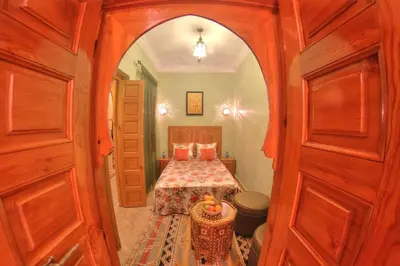 a bedroom with a bed in a room with an archway at Dar Tasnime in Marrakech