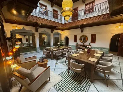 a restaurant with tables and chairs in a building at Riad Atlas Acacia in Marrakech