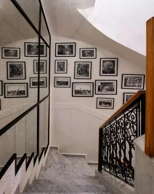 a staircase with framed pictures on the wall at Riad Atlas Acacia in Marrakech