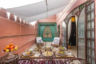 a balcony with a table with plates of food on it at Riad Lamya Marrakech in Marrakech