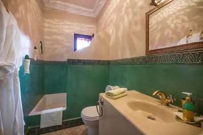 a bathroom with a sink and a toilet and a mirror at Riad Lamya Marrakech in Marrakech
