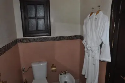 a bathroom with a toilet and a sink and a window at Riad Lamya Marrakech in Marrakech