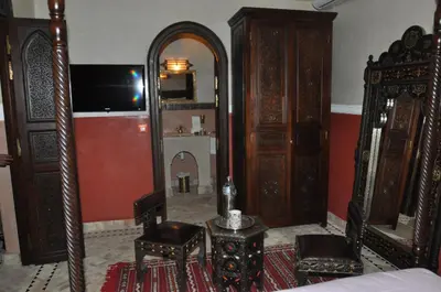 a bedroom with a mirror and a bed and a table at Riad Lamya Marrakech in Marrakech