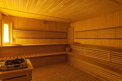 a empty wooden sauna with a window and benches at Savoy Le Grand Hotel Marrakech in Marrakech