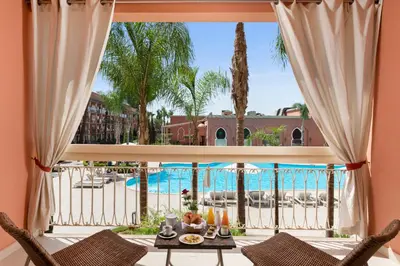 a view of the pool from the living room of a resort at Savoy Le Grand Hotel Marrakech in Marrakech