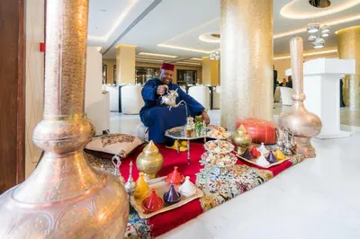 a man sitting in a room with a bunch of vases at Savoy Le Grand Hotel Marrakech in Marrakech