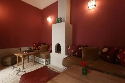 a living room with a couch and a fireplace at Riad Dar Ayur in Marrakech