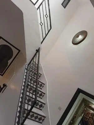 a hallway with a staircase with a light and a ceiling at Ryad Ayad in Marrakech