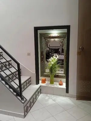 a hallway with a mirror and a vase of flowers at Ryad Ayad in Marrakech
