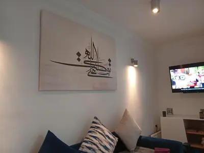 a living room with a couch and a painting on the wall at Ryad Ayad in Marrakech