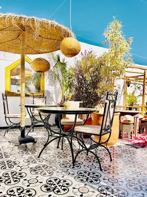 a table and chairs under an umbrella on a patio at Riad Argan in Marrakech