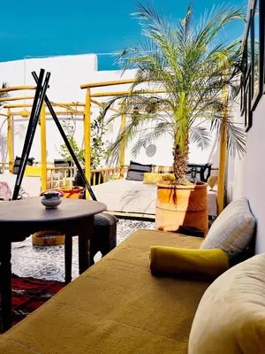 a living room with a couch and a palm tree at Riad Argan in Marrakech