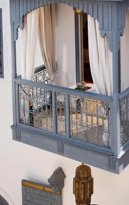 a blue balcony with curtains and a mirror at Riad Adore in Marrakech