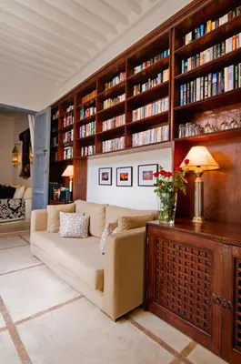 a living room with a couch and bookshelves at Riad Adore in Marrakech