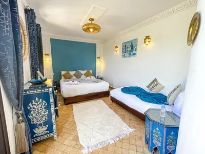 a bedroom with two beds with blue and white at Riad des Lys in Marrakech