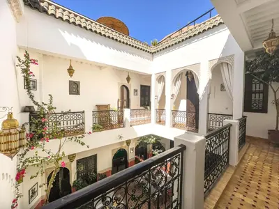 a courtyard of a house with a balcony at Riad des Lys in Marrakech