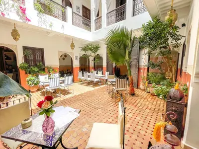a room with tables and chairs in a building at Riad des Lys in Marrakech