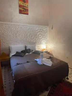 a bedroom with a bed with a towel on it at Riad Jenan Adam in Marrakech