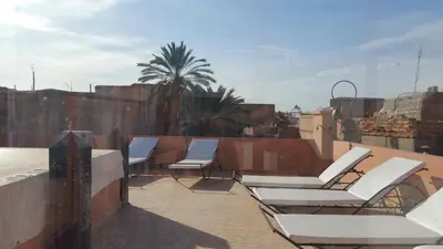 a group of chairs sitting on top of a roof at Riad Jenan Adam in Marrakech