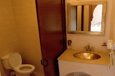 a bathroom with a sink and a toilet and a mirror at Riad Jenan Adam in Marrakech