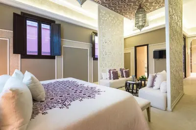 a bedroom with a white bed and a couch at Riad Elisa & Spa in Marrakech