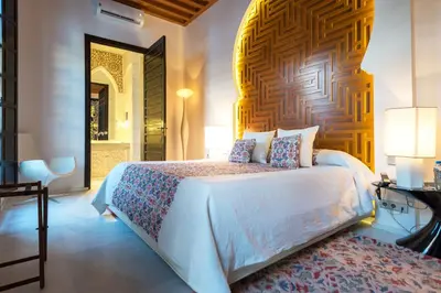 a bedroom with a white bed with a wooden wall at Riad Elisa & Spa in Marrakech